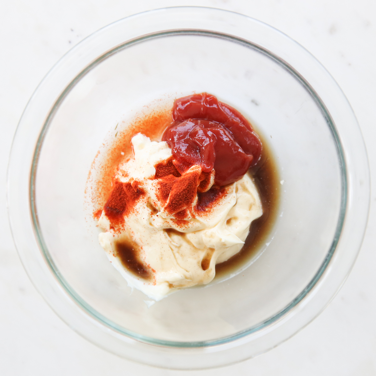 mayo, ketchup, and seasonings in a glass bowl