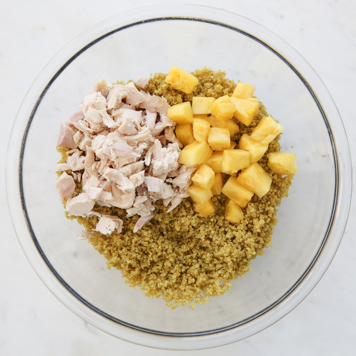Cooked quinoa and pineapple in a glass bowl
