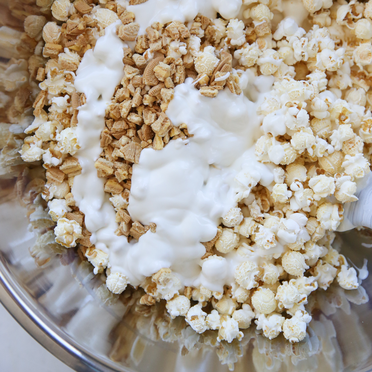 Melted white chocolate over popcorn and cookies