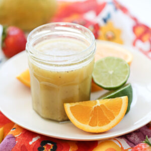 Honey Citrus Vinaigrette in a jar surrounded by citrus