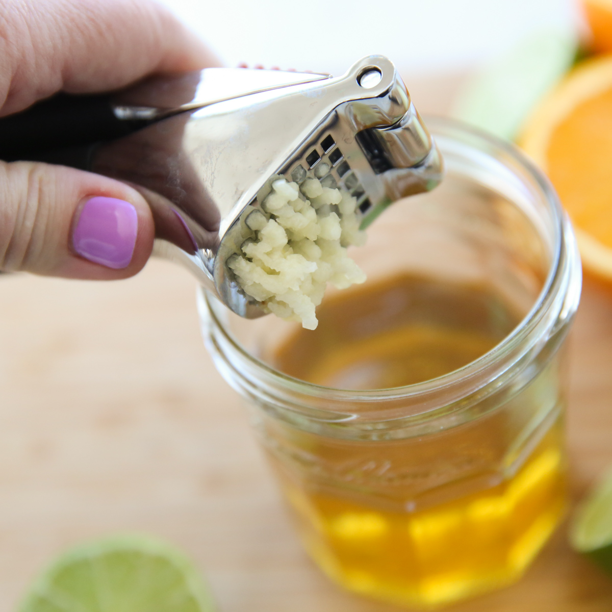 garlic being pressed through a garlic press