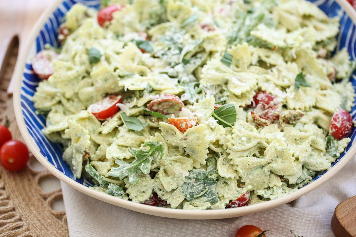 creamy pesto basil pasta in a blue and white serving bowl