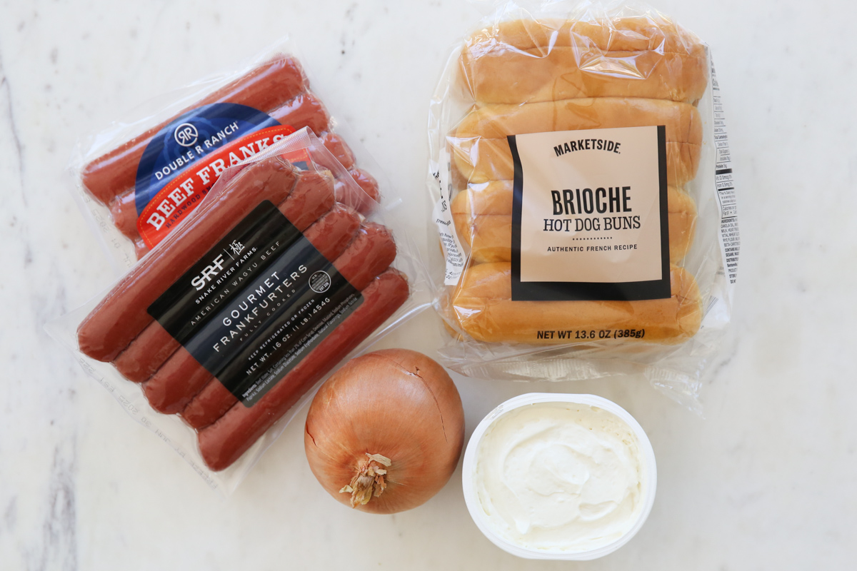 hot dog, buns, onion and cream cheese on a table