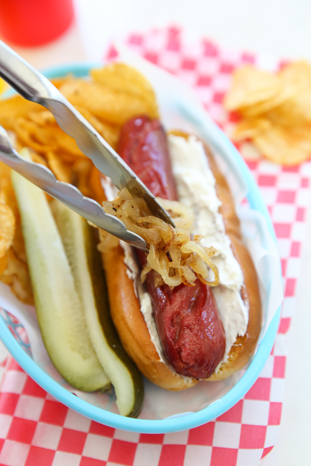 placing caramelized onions on a hot dog