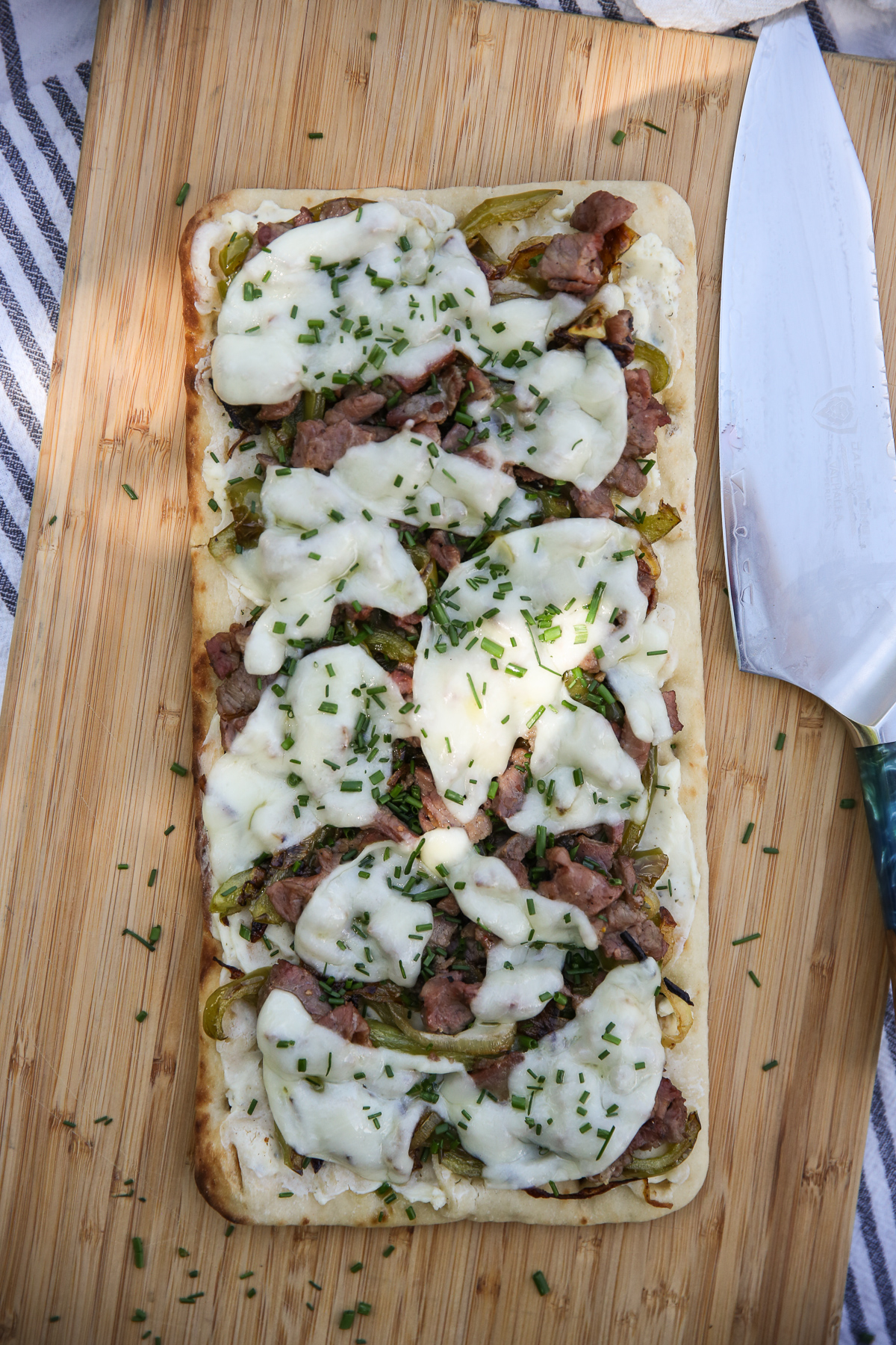 Cheesesteak flatbread on a cutting board