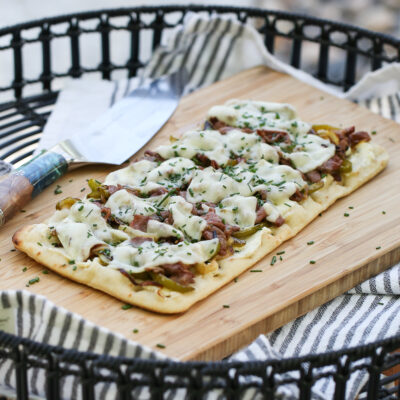 Cheesesteak flatbread on a cutting board
