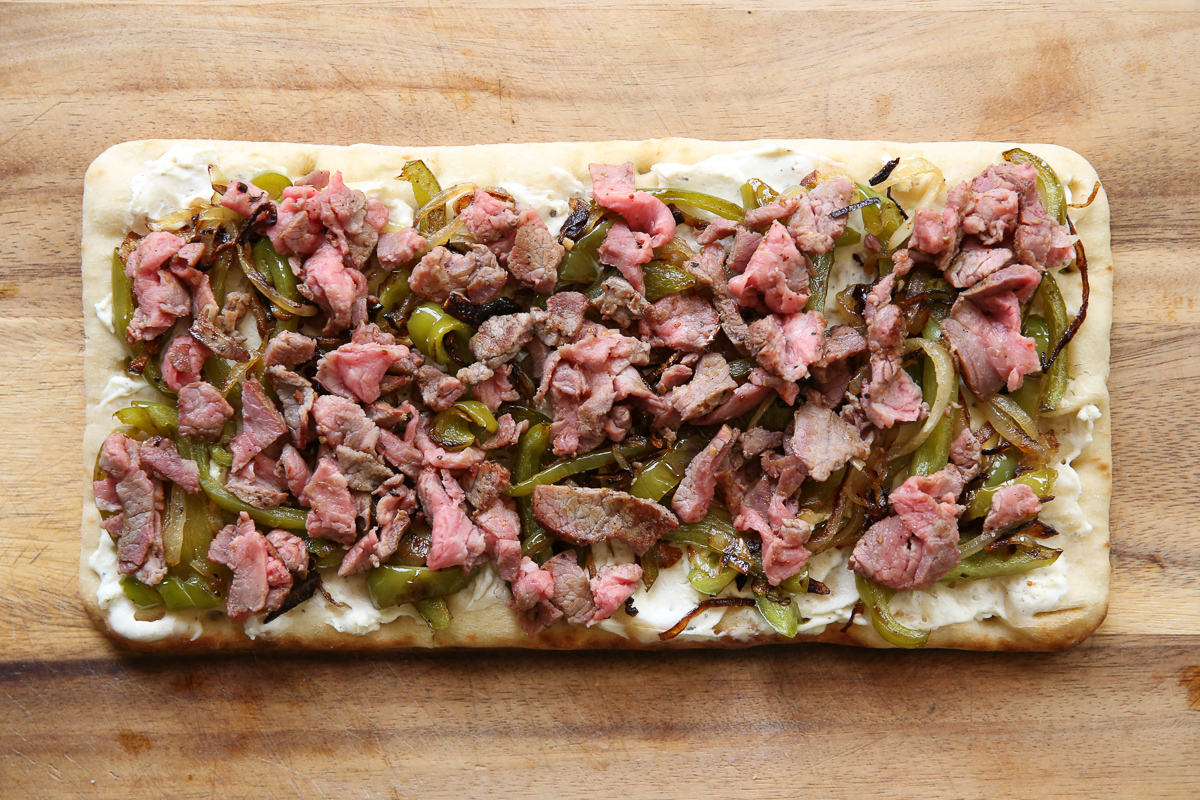 Cheesesteak flatbread on a cutting board
