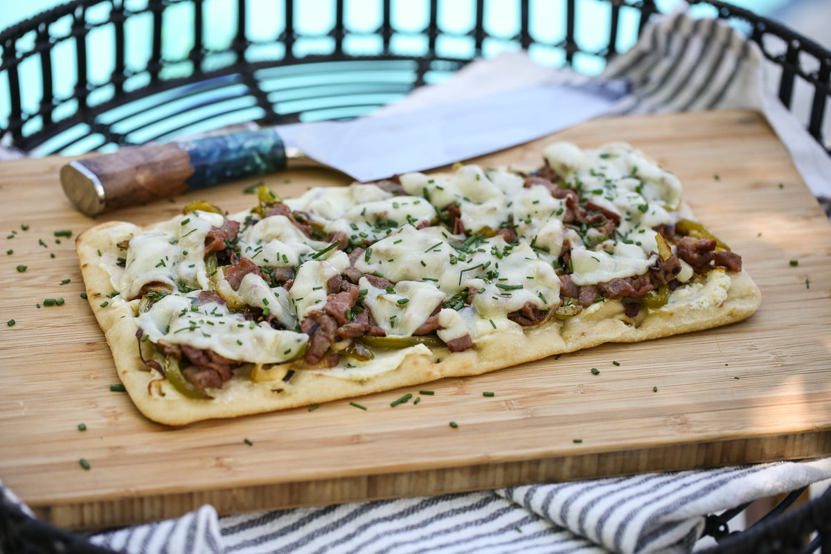 Cheesesteak flatbread on a cutting board