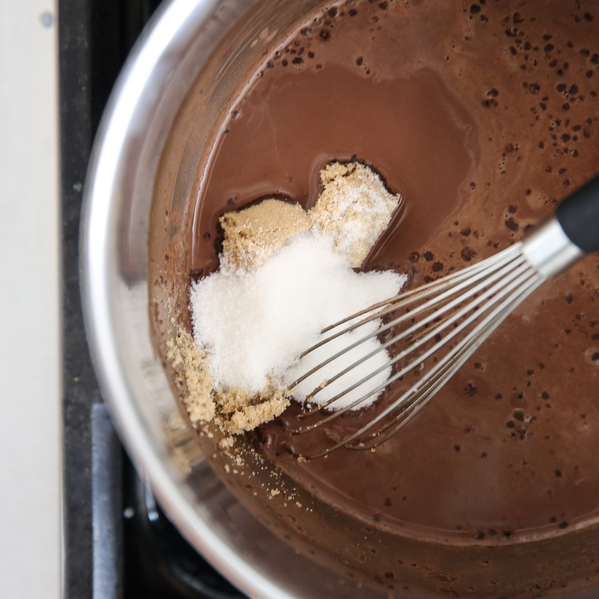 sugar in melted cocoa milk on the stove