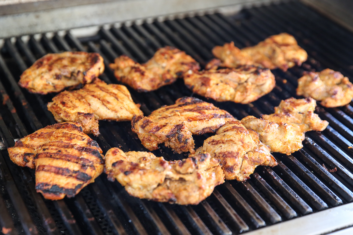 chicken thighs cooking on a grill