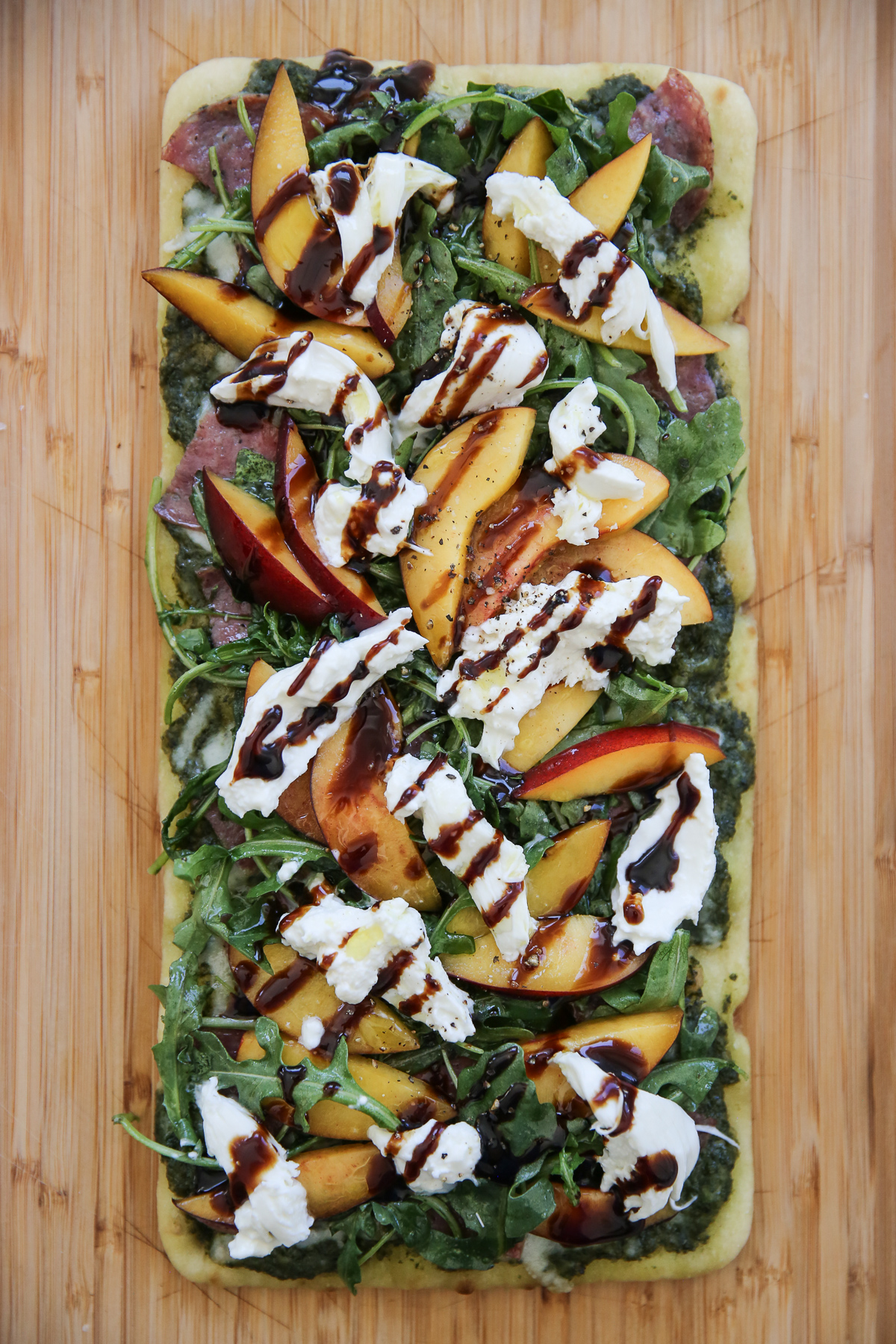 Cooked flatbread with salami and cheese and greens