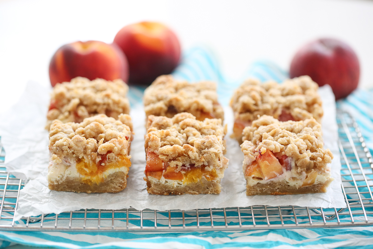 peach crumble cheesecake bars on a tray