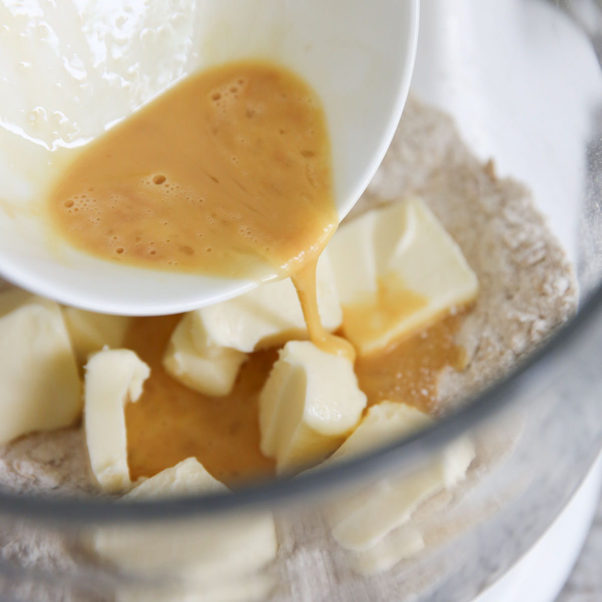egg and vanilla being poured into dry ingredients