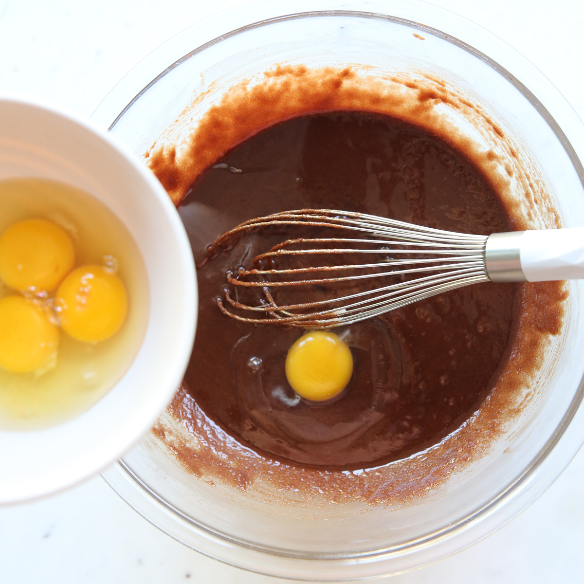 dropping eggs into brownie batter