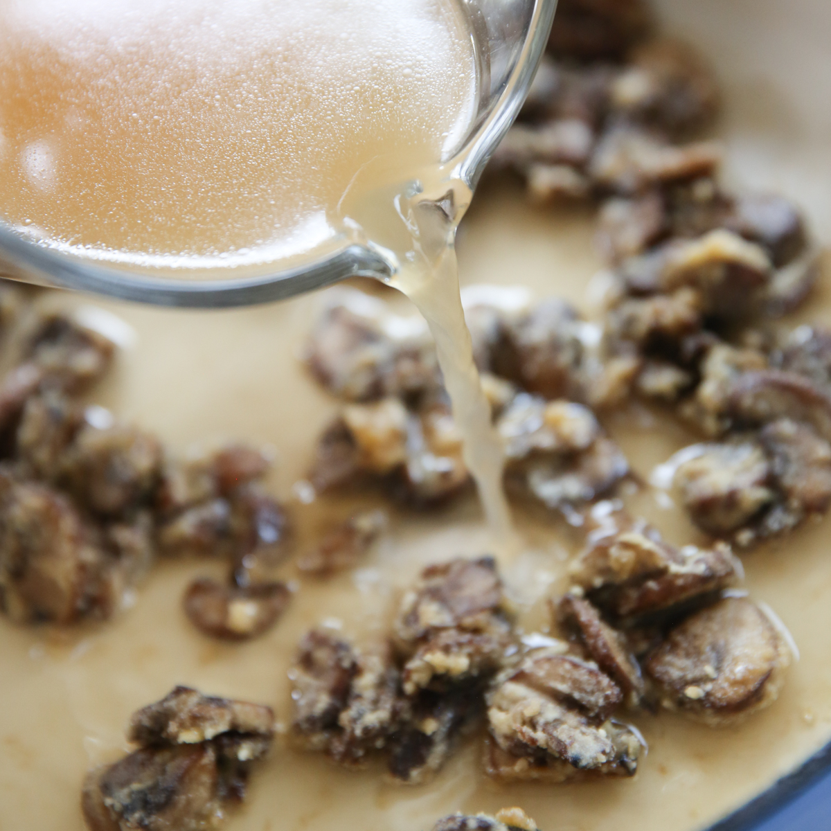 adding broth to fresh green bean casserole