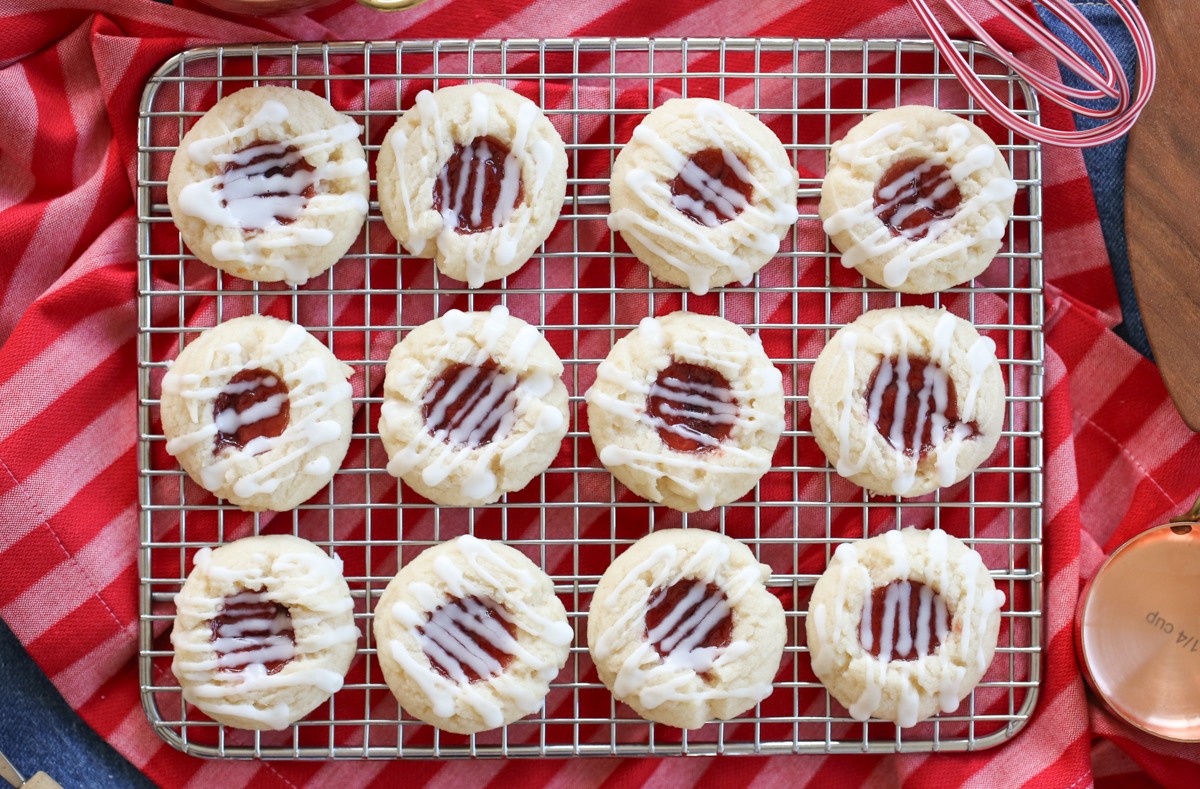 raspberry thumbprint cookies on a baking rack
