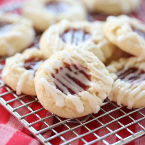raspberry thumbprint cookies on a baking rack