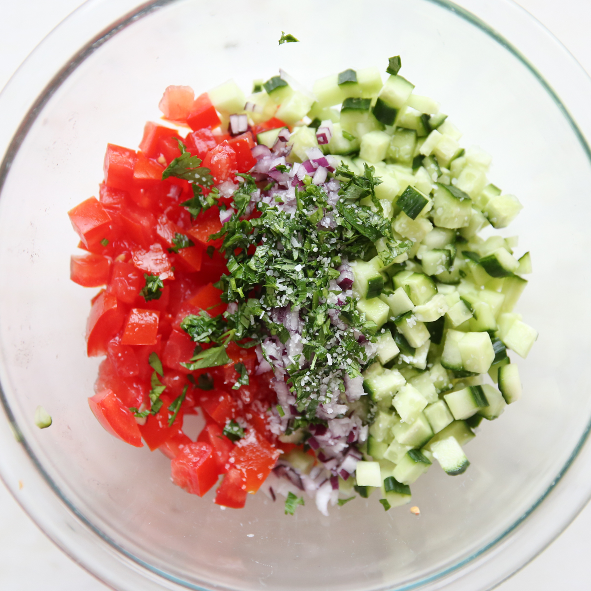parsley, tomato, cucumber and onion in a bowl