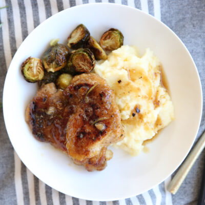 glazed maple cider chicken on a plate with potatoes and veggies
