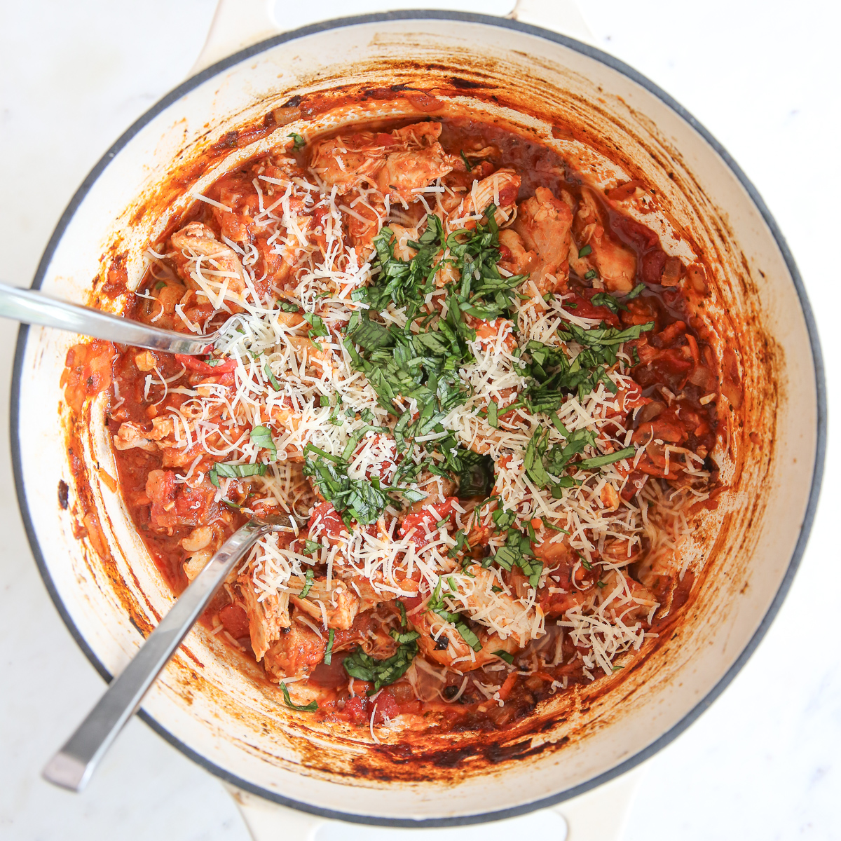 Fresh parmesan cheese and basil are added to the pot before serving.