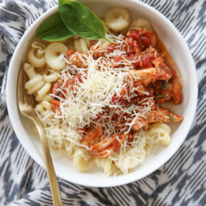 Braised Italian Chicken with pasta in a bowl with fresh basil