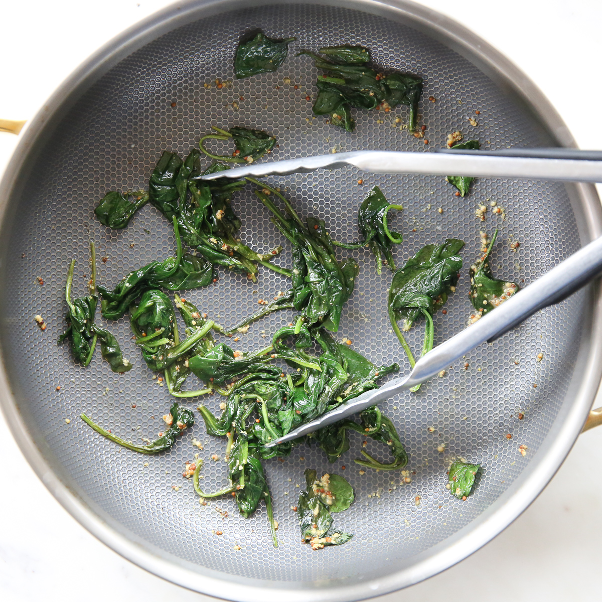 wilted spinach in a saute pan