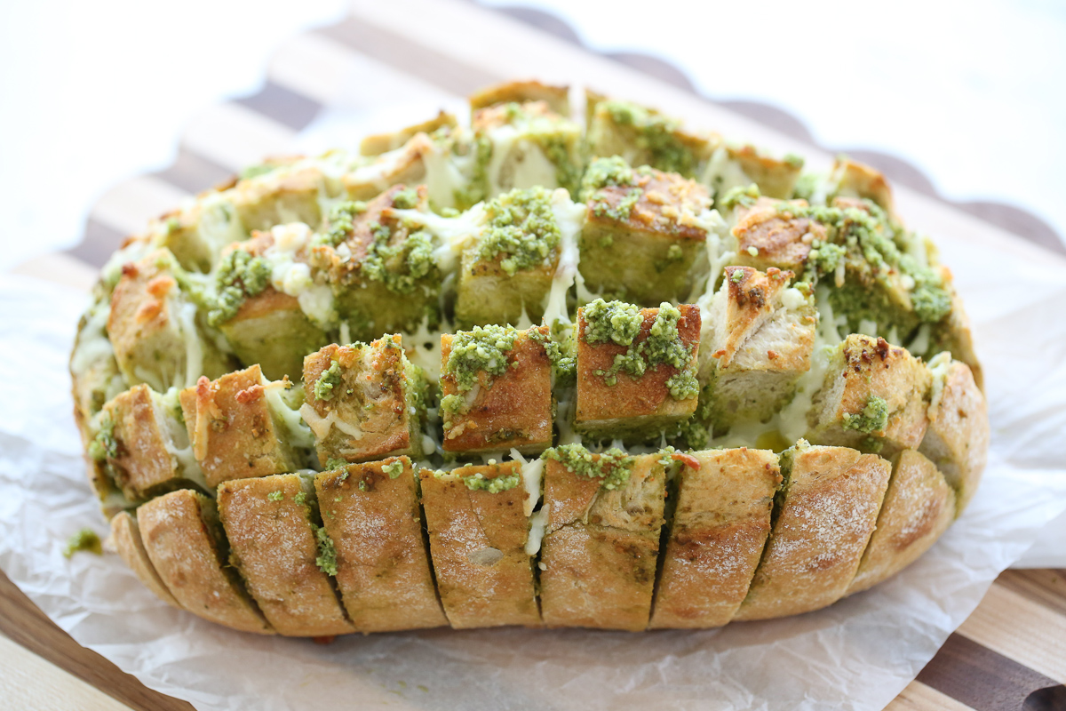 loaf of garlic pesto bread on a cutting board