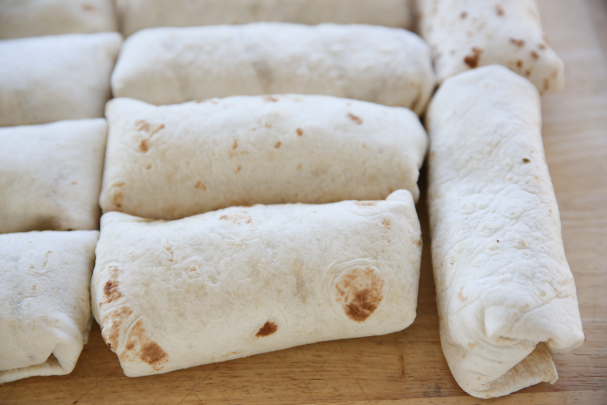 rolled burritos on a cutting board