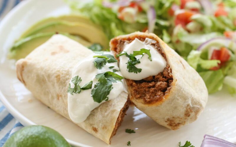 burrito sliced in half on a white plate