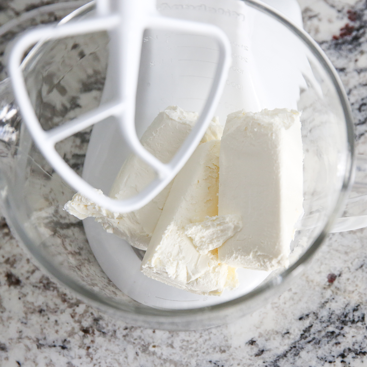 bricks of cream cheese in a kitchenaid mixing bowl