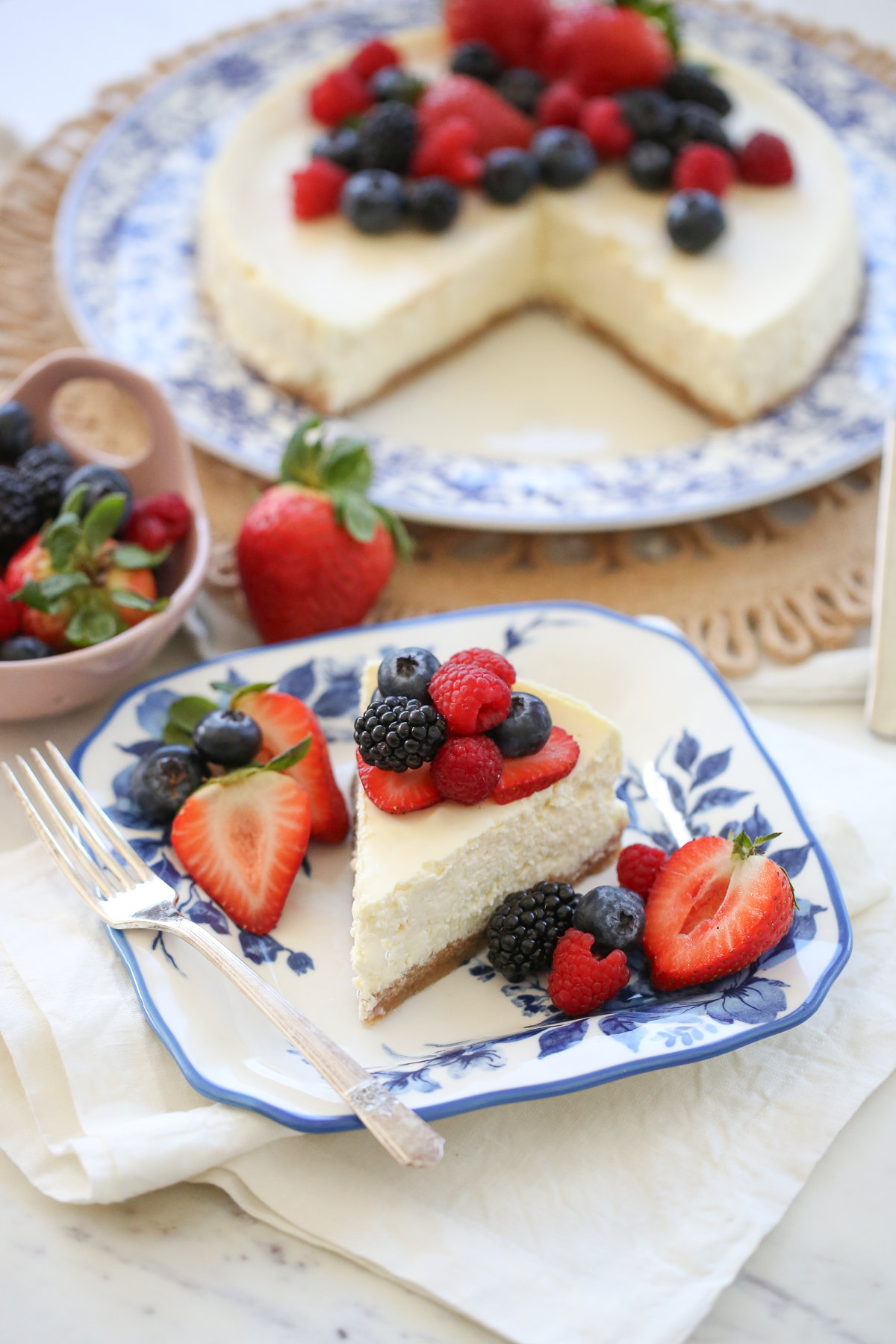 slice of cheesecake on a plate with fresh berries
