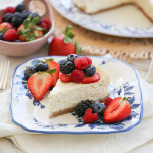 slice of cheesecake on a plate with fresh berries