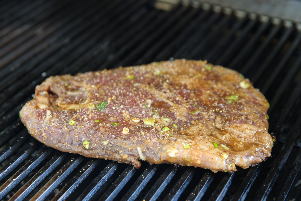 Ginger Soy Flank Steak cooking on a bbq grill