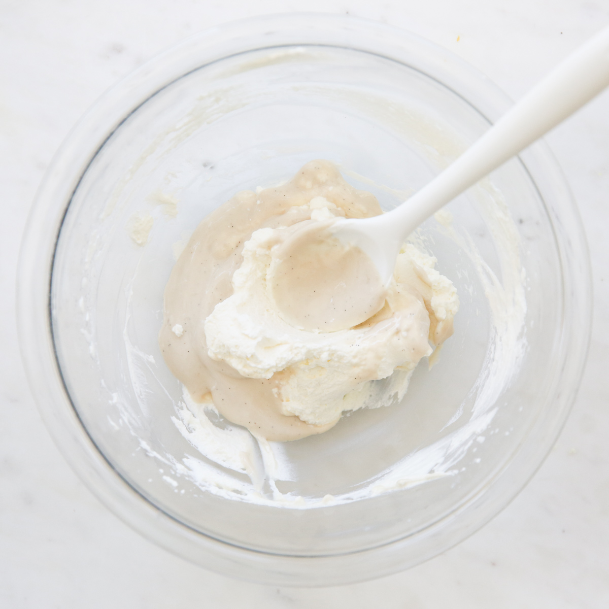 folding cream into a bowl of topping