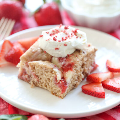 slice of strawberry swirl cake on a plate with fresh berries