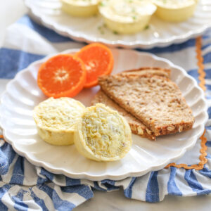 chili cheese egg bites on a plate with oranges and toast