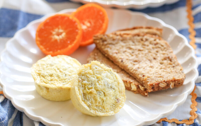 chili cheese egg bites on a plate with oranges and toast