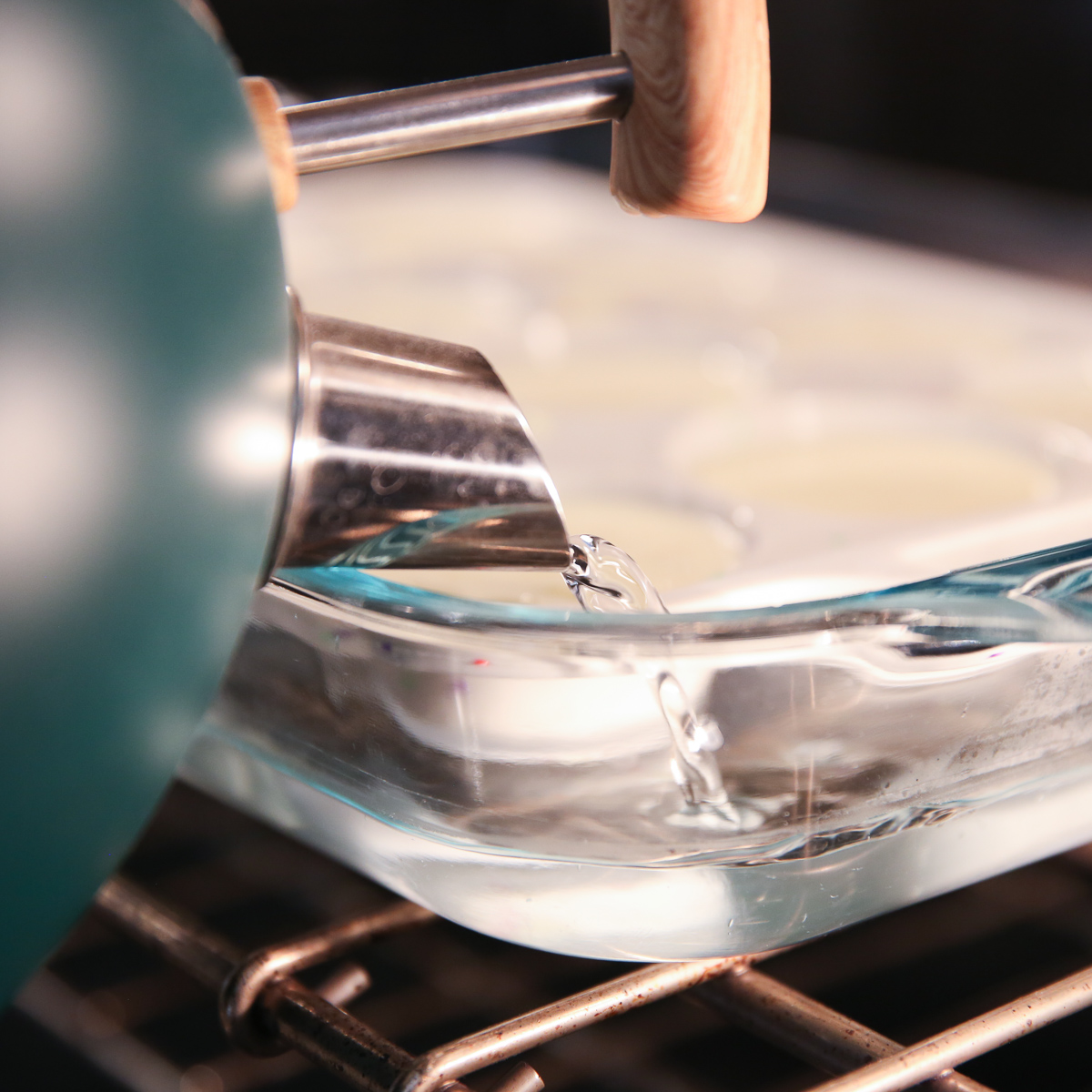 pouring water into a pan with a muffin tray