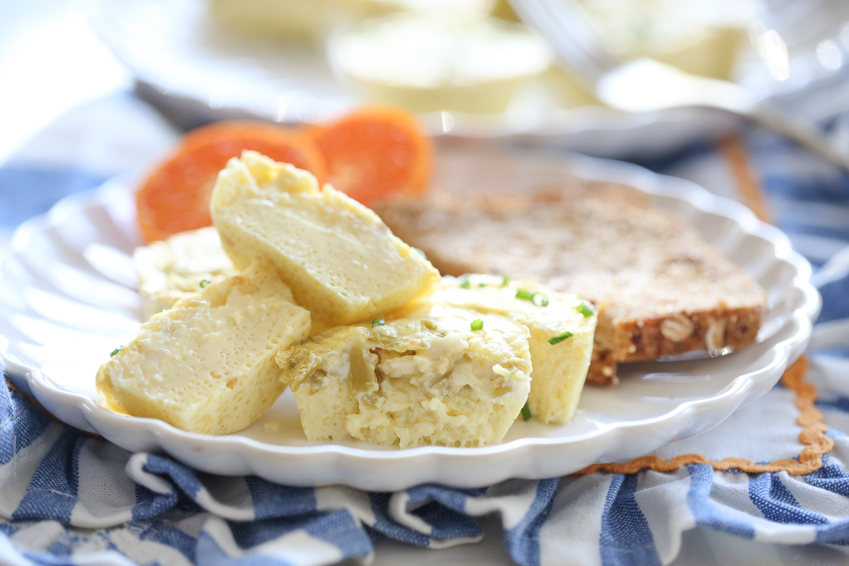 chili cheese egg bites on a plate with oranges and toast