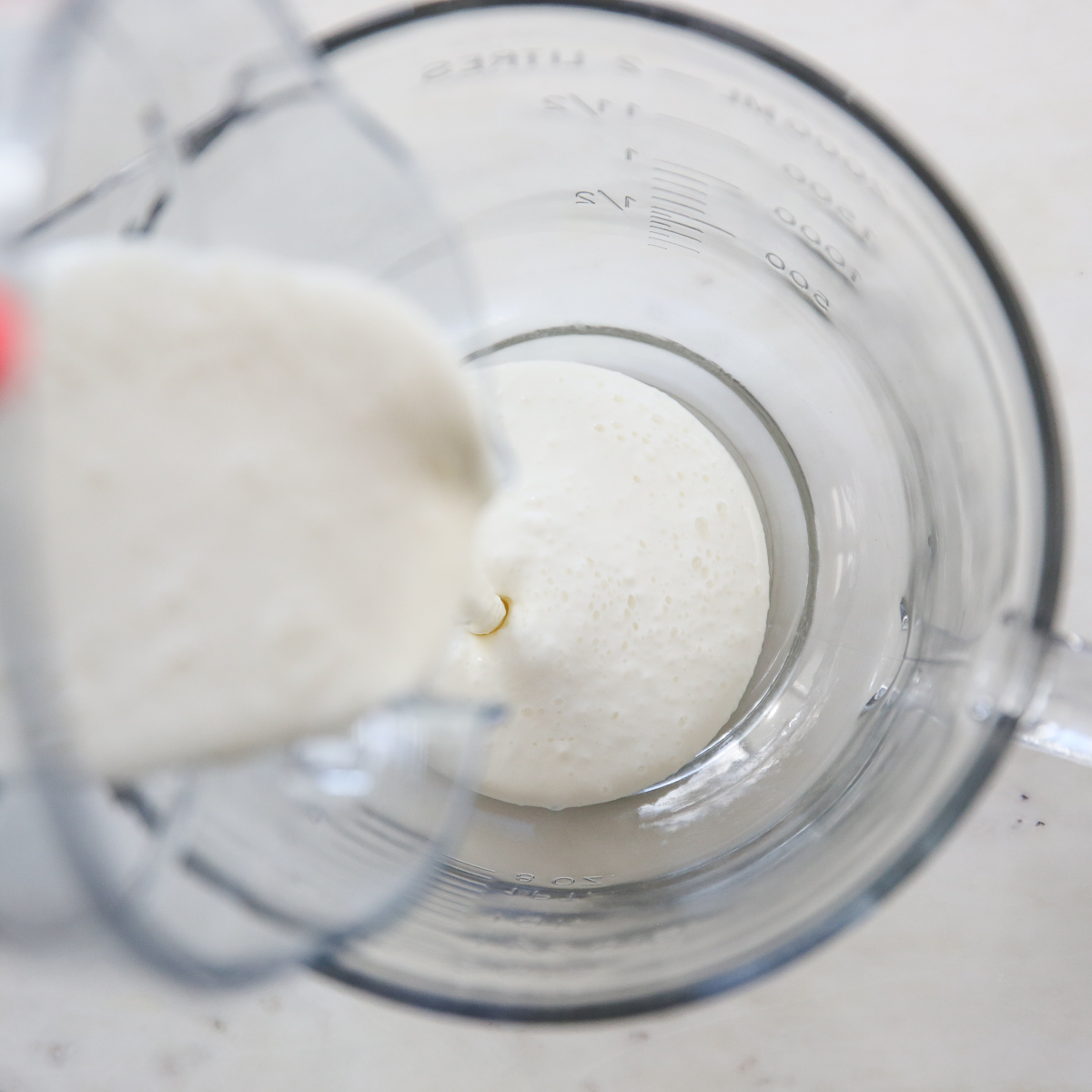 cottage cheese mixture being poured from blender into a bowl